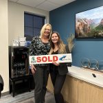 Lesley and her client holding a sold sign